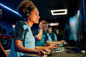 Woman gamer trying hard to win game in cyber club