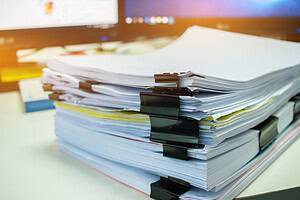 Stacks of documents files for finance of office working.Business report papers or Piles of unfinished document achieves with black clip paper. Concept of Business Annual Report.