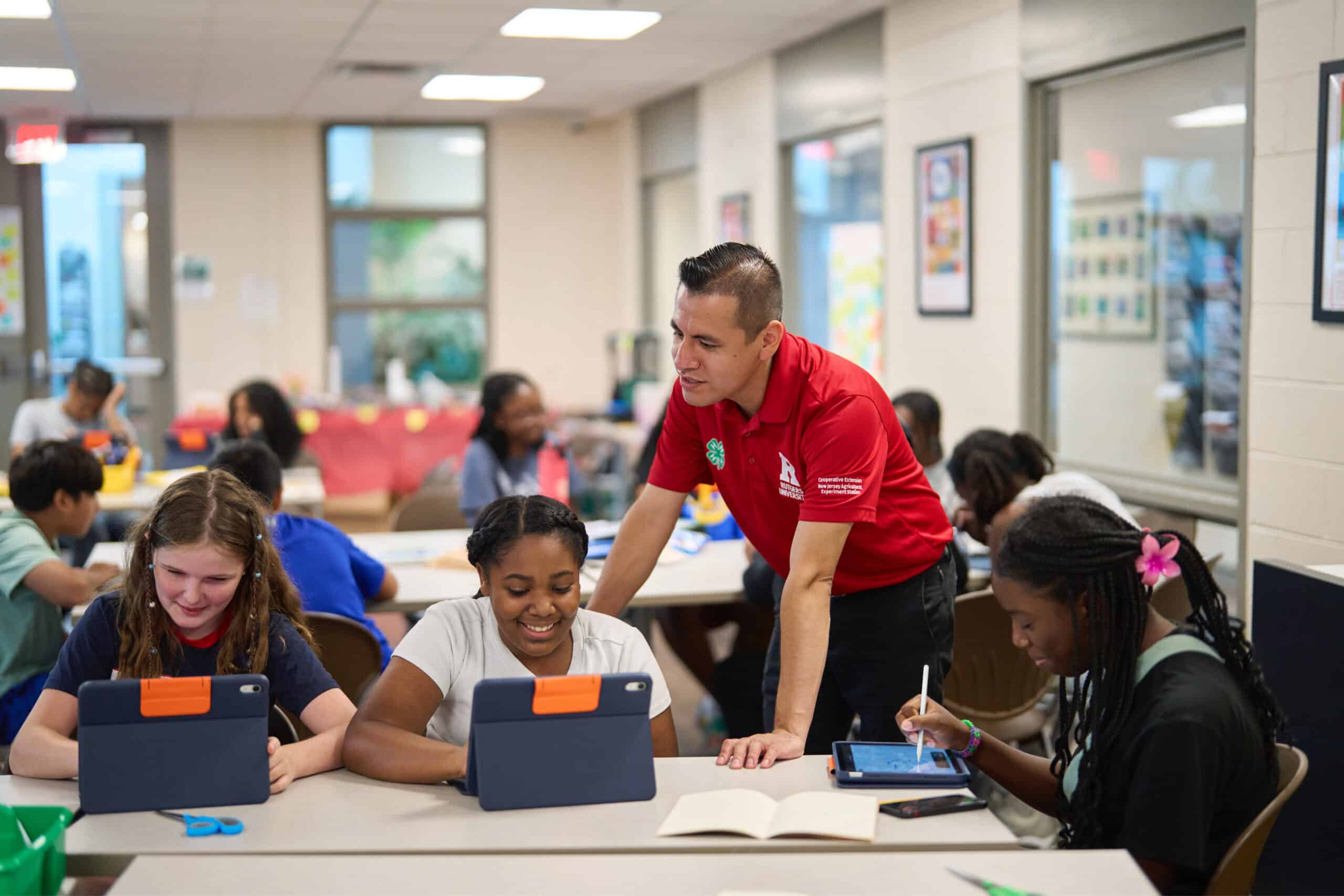 Apple US investment 4 H teacher reviewing student work