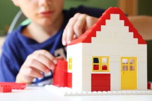 Junge baut mit Bausteinen sein Traumhaus