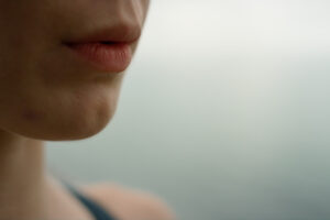 Girl doing breathing exercise on beach closeup. Woman practicing yoga meditation